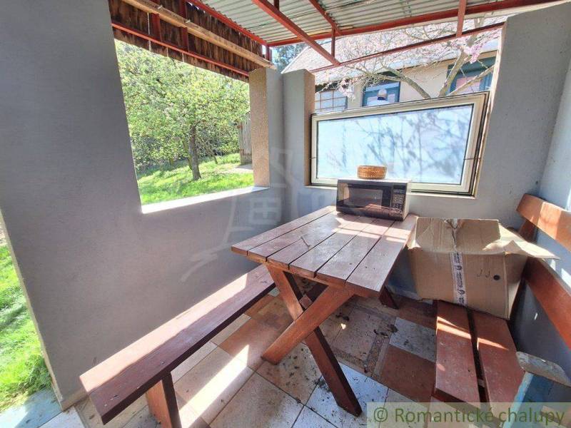 Rustic wooden table and benches with a view of the garden.