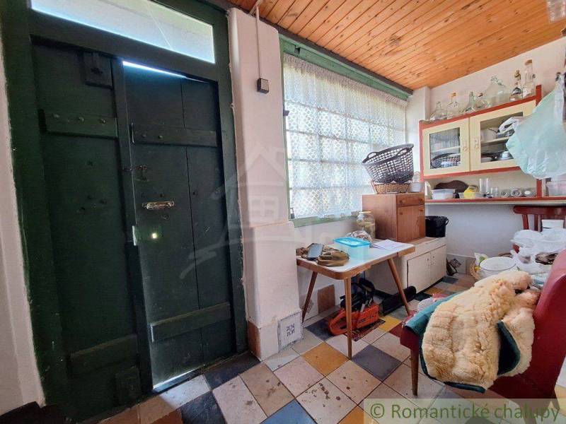Interior of a cabin with wooden doors, a table, and vintage furniture, cozy atmosphere.