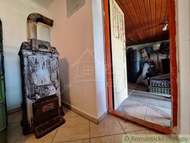 The interior of the cottage with tiles next to the door leading to the storage space.