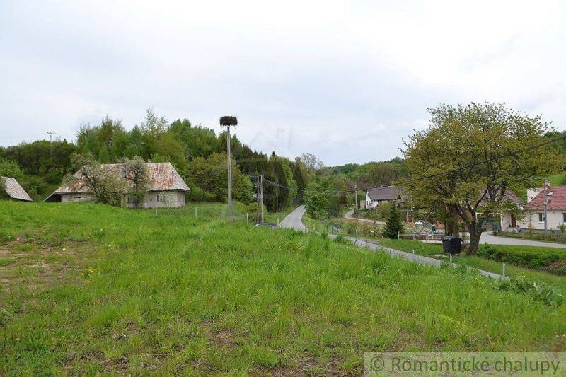 A rural landscape in Kečkovce with green gardens, houses, and a country road.