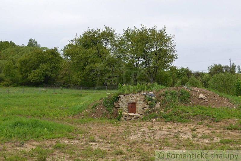Gardens in Kečkovce with a stone cellar surrounded by grass and trees.