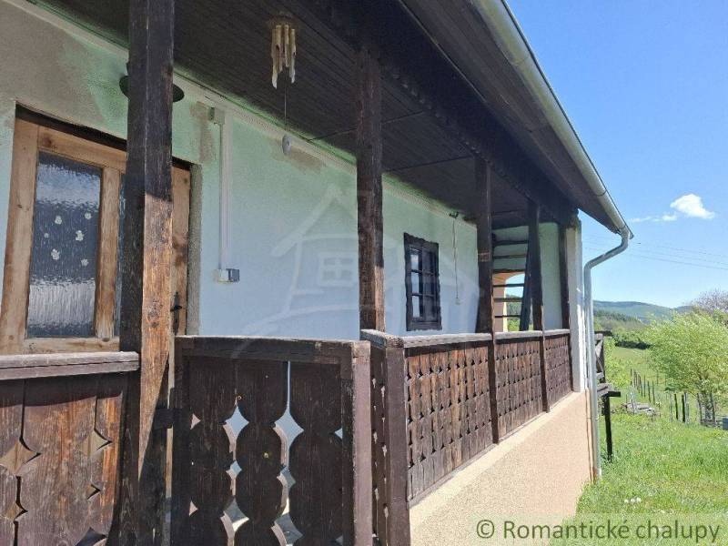 A wooden veranda at the cottage in Podkriváň with a view of the surrounding nature.