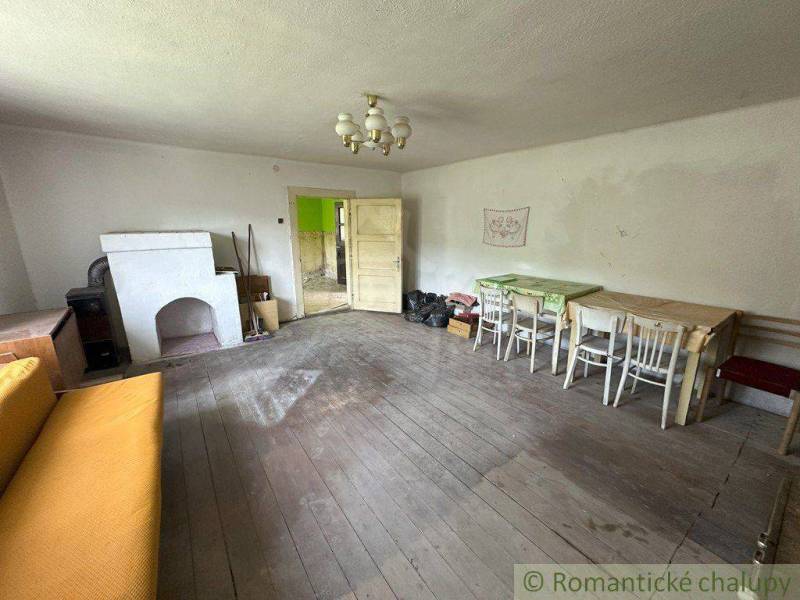 Room in a family house with wooden flooring, a sofa, and a stove.