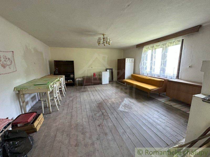 In the family house, there is a wooden floor, a table with chairs, and a sofa.