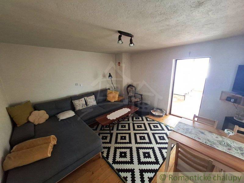 Living room with a corner sofa and a patterned carpet in a family house.