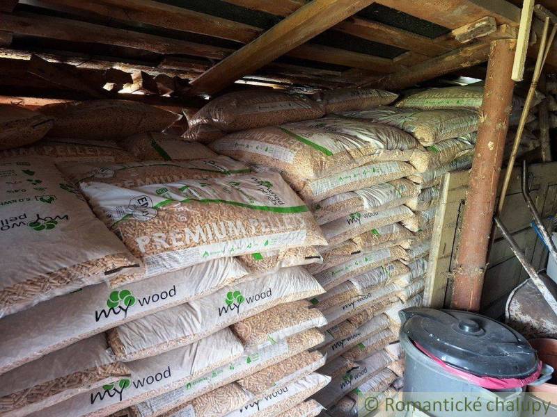 A pellet storage room in a family house with wood and a bucket.