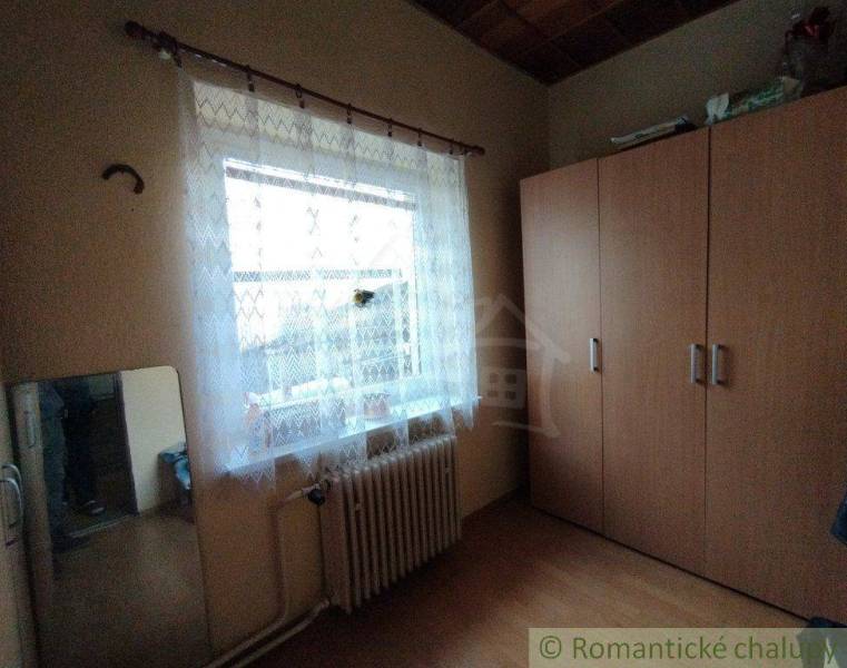 A room with a wardrobe, a mirror, and a window, located in a family house.