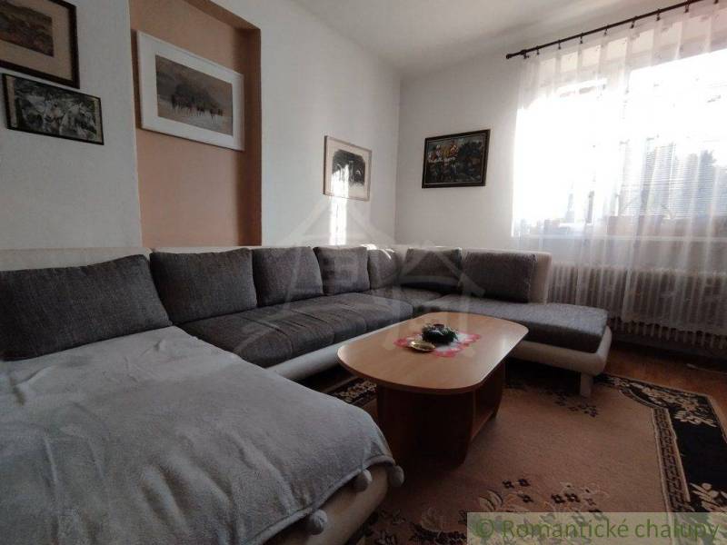 Living room with a comfortable couch and a wooden table in a family house.