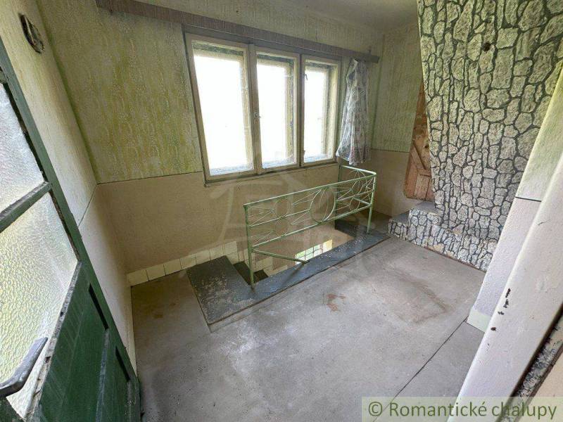 Interior of an older house with a staircase and a stone-clad wall. Family house.