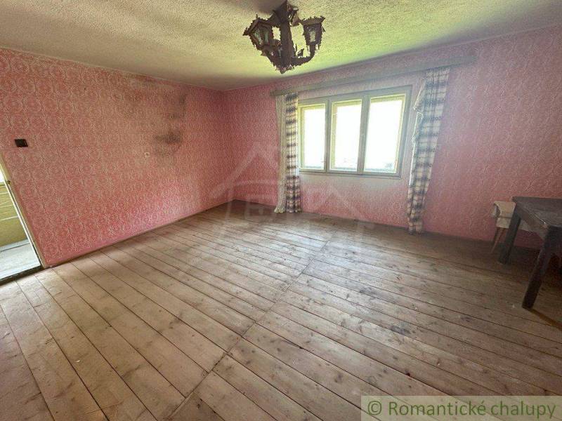 A place with wooden flooring, pink walls, and a window, suitable for a family house.