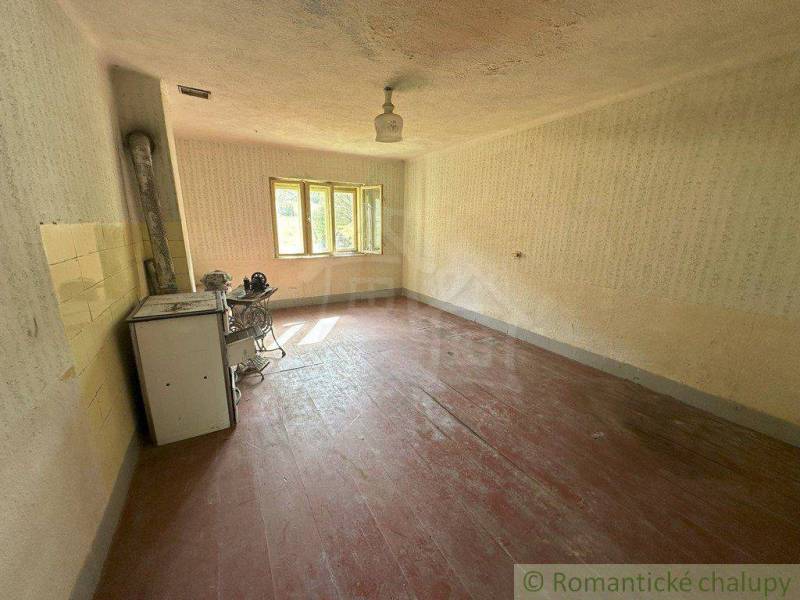 The interior of a country family house with a wooden floor and an old stove.
