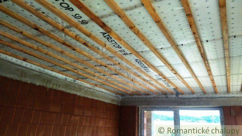 Ceiling insulation and construction in a family house, wooden beams and masonry.