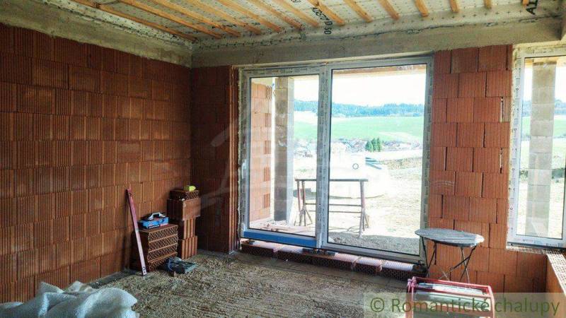 Construction of a family house with a view of the landscape, bricks in the interior, unfinished spaces.