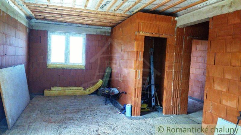 Unfinished interior of a family house with construction materials and brick walls.