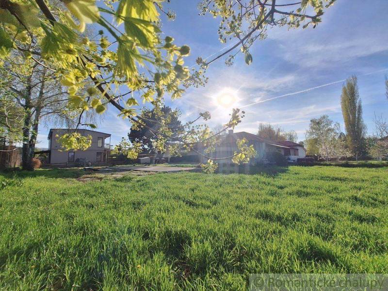 A grassy area with a house, the sun above the garden, spring, an ideal place to live.