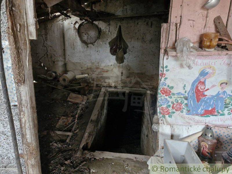 An abandoned room in a family house with a well and a religious painting.