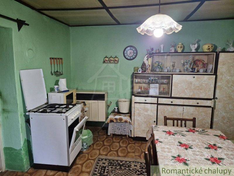 Traditional kitchen in a family house with antique cabinets, oven, and decorations.