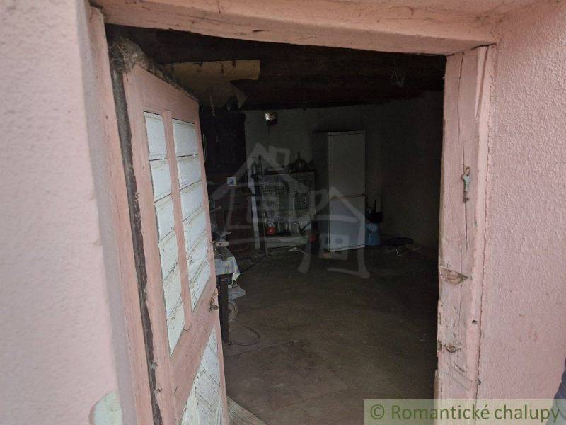 An ancient interior of a country house with old furniture and worn-out walls.
