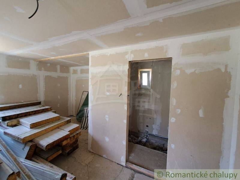 A room under renovation with wooden boards in a building where a cabin is under construction.