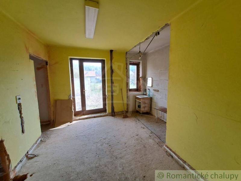 Interior of a family house with yellow walls, an empty room, and a countryside view.