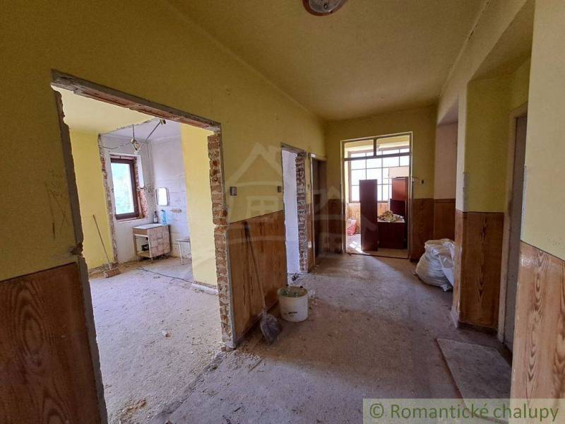 The interior of a house under renovation with open rooms, plaster, and yellow walls.