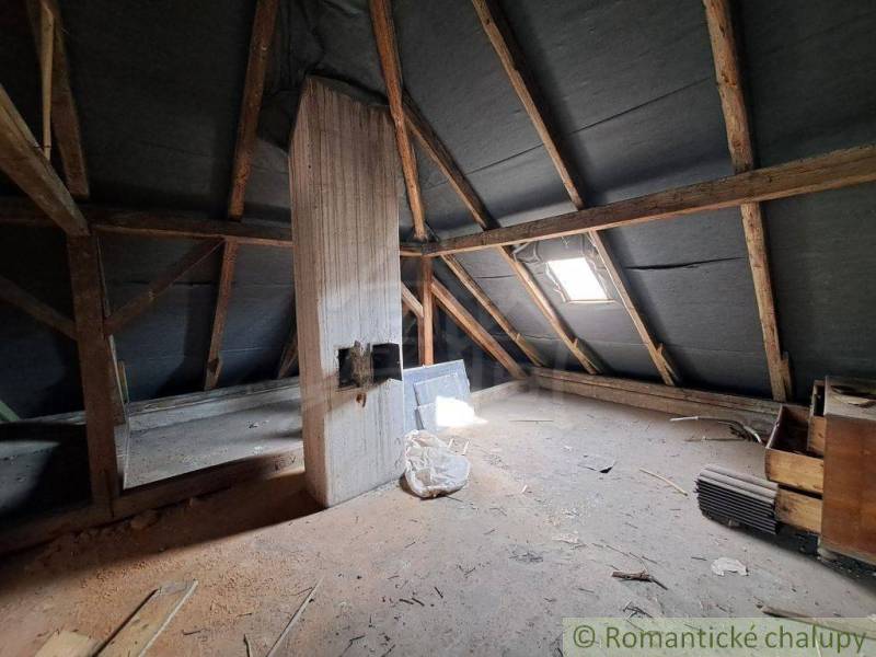 The attic of a family house with wooden beams and a skylight. Romantic cottages.