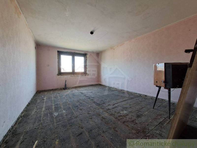 An empty room with a window, unfinished floor suitable for a family house.