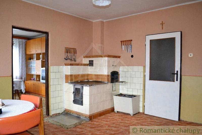 Traditional kitchen with a brick stove and wooden furniture in a family house.