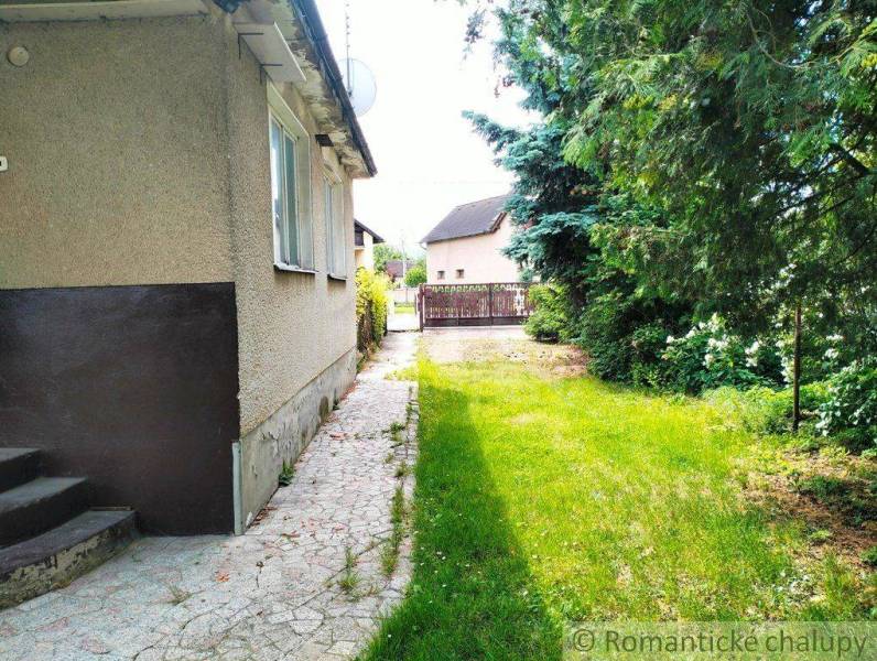 A family house in Košeca surrounded by a garden with greenery and a walkway.