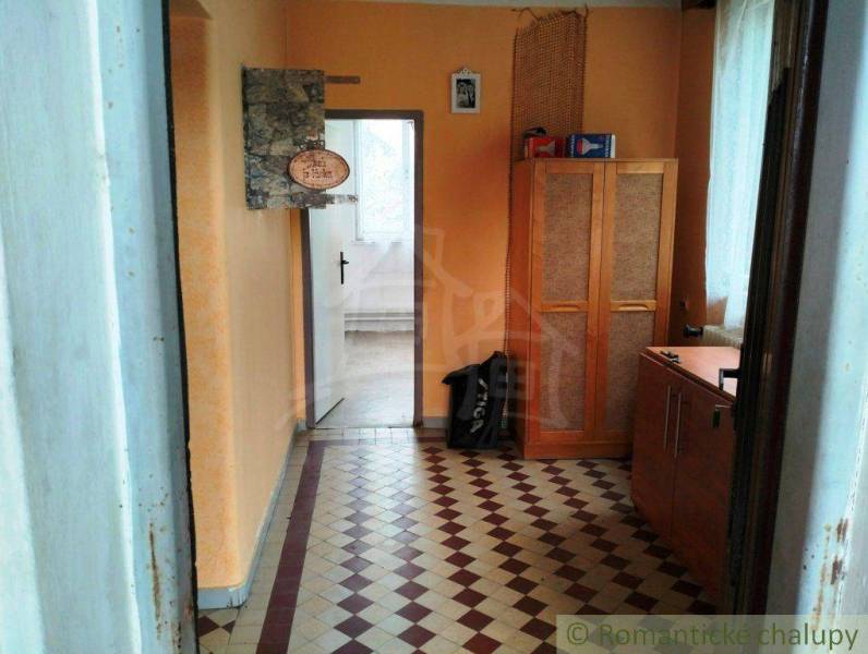 A hallway with yellow walls, tiles, a wooden wardrobe. A family house with a cozy interior.