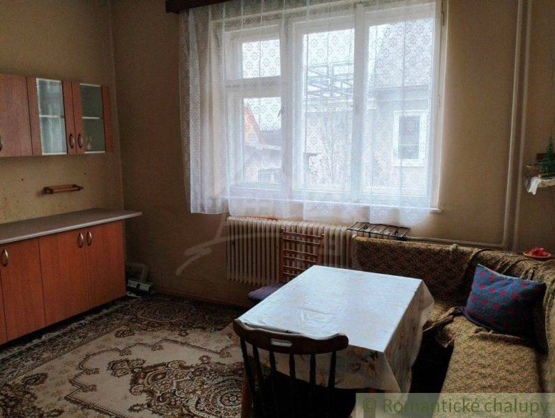 A room in a family house with a wooden wardrobe and a table near the window.