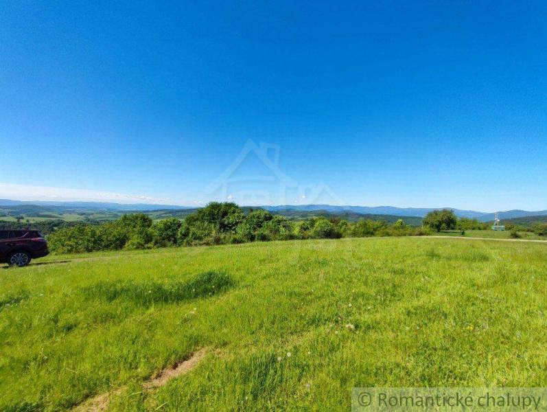 Green meadows and blue skies with a view of the hills create a scenery.