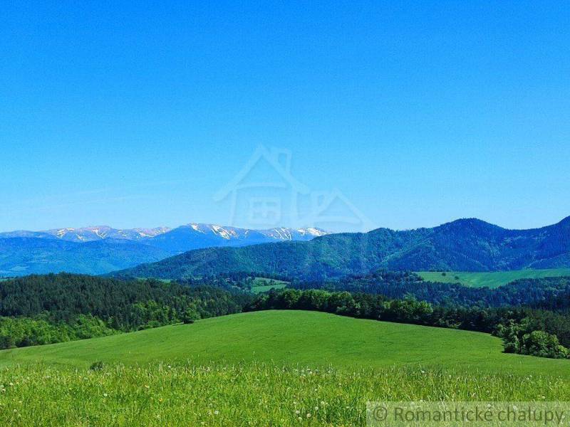 Peaceful landscape, hills, mountains with snow, meadows, trees, blue sky, with gardens.