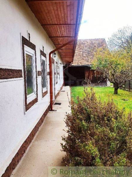 A family house with a wooden roof, garden, tree; a natural environment for a peaceful life.