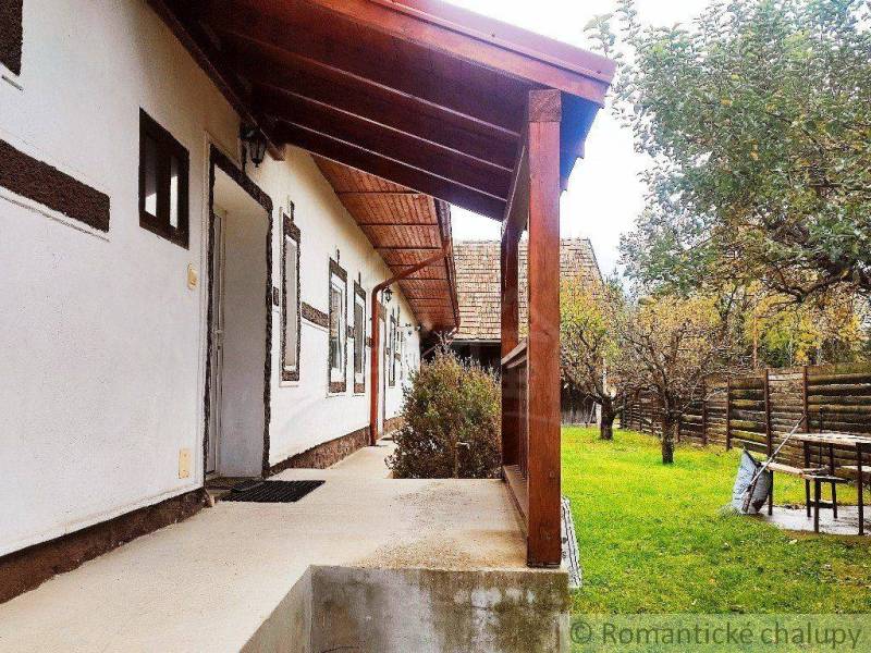 Wooden terrace with a garden around a family house in a traditional rural style.