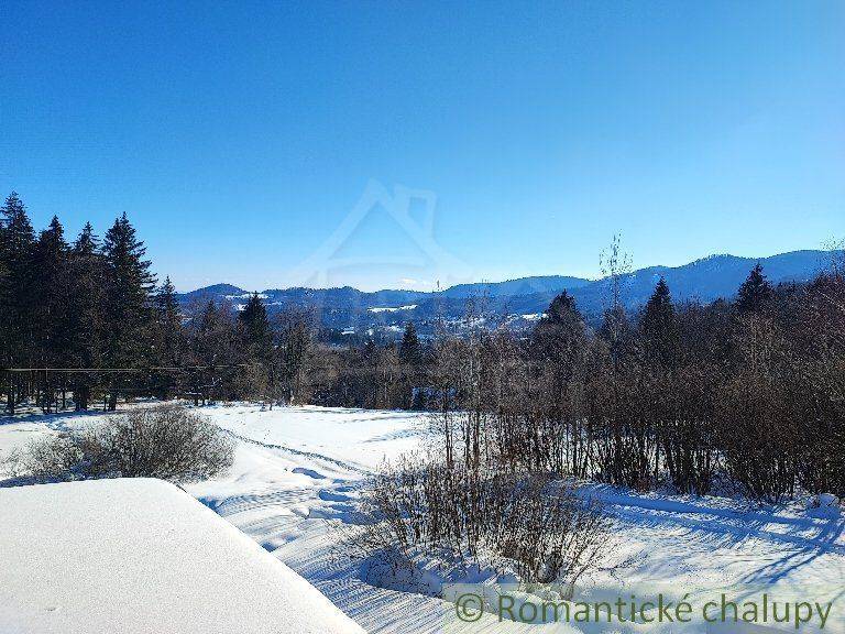 A snowy landscape with a view of mountains and trees, suitable for a family house.