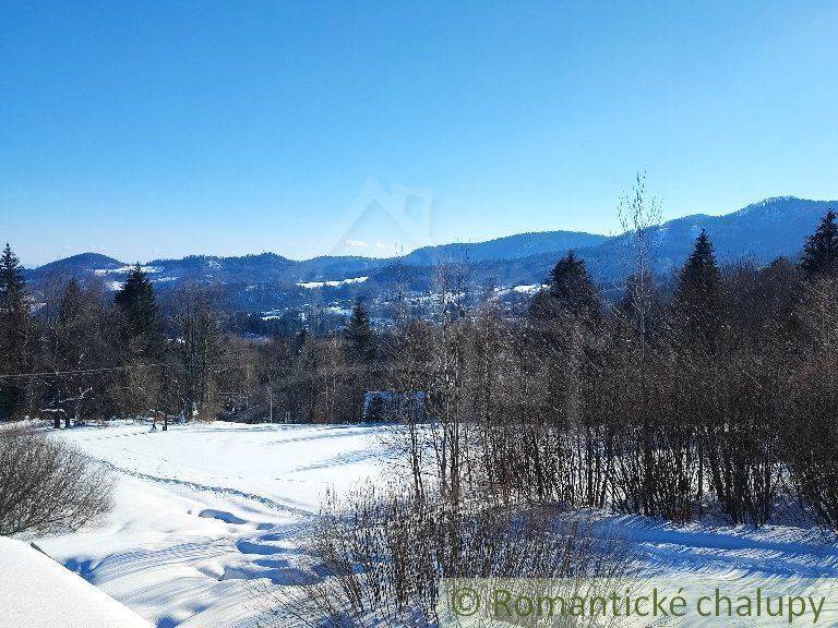 Winter landscape with mountains, trees, and a beautiful view from the **terrace** of a family house.