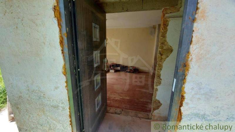 The image shows the entrance to the interior through open doors of a family house.