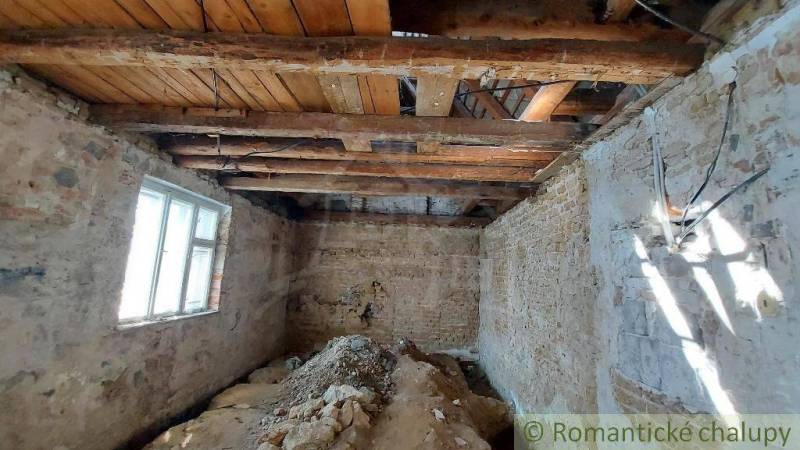 Renovation of an old family house: exposed wooden beams and stone walls.