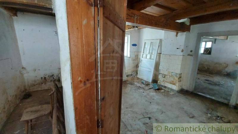 An abandoned interior in a family house needs renovation, old doors and walls are visible.