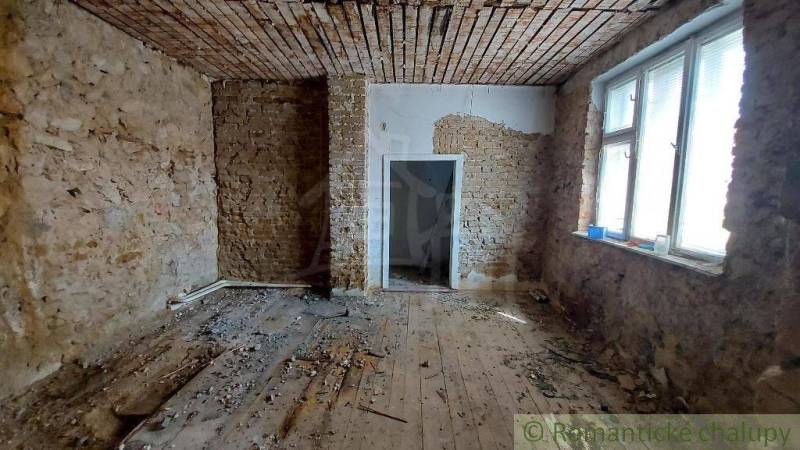 A room in a vineyard house with a brick ceiling and old wooden flooring.