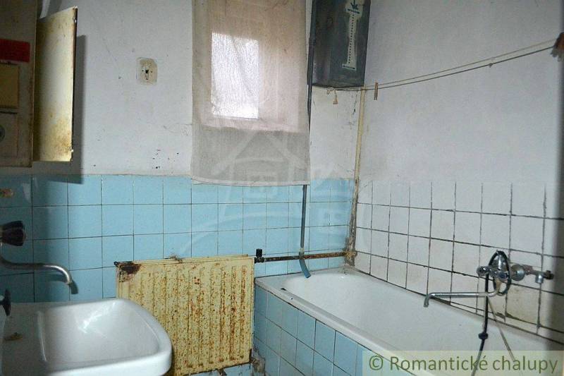 Bathroom of a family house with a bathtub, sink, blue and white tiles.