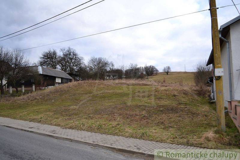The image shows agricultural and forest land with rural landscape and the edge of a village.