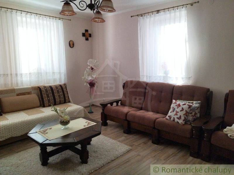 A family house with a cozy living room, wooden furniture, and pleasant decorations in a retro style.