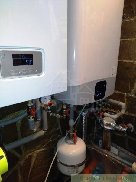 The image shows a boiler room with modern boilers and piping in a family house.
