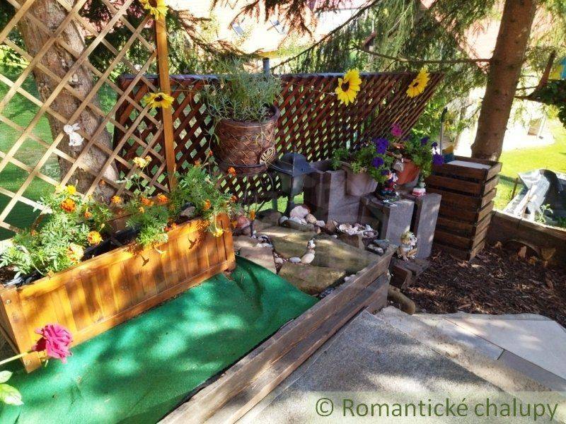 A floral decoration with sunflowers and wood adorns the garden by the house.
