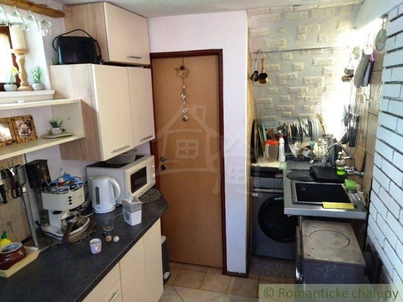 A kitchen in a family house with white cabinets, a stove, and cooking equipment.