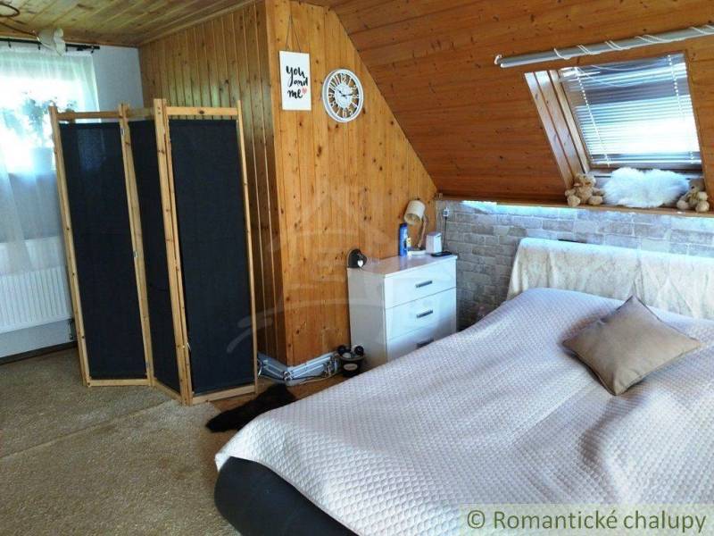 Attic room, wooden paneling, screens, bed, window with blinds, interior of a family house.