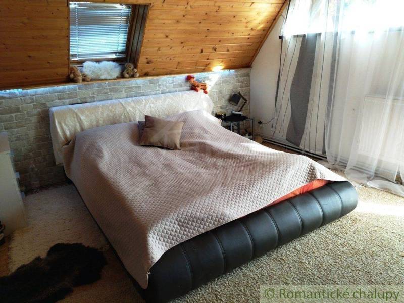Loft bed with blanket, pillows, and curtains, suitable for a family house.