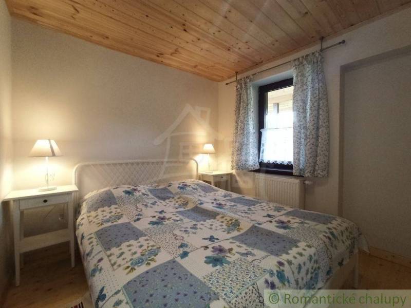 A cozy room in a wooden cabin, a bed with lamps, a pleasant cabin atmosphere.